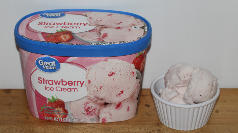 Great Value strawberry ice cream container with a bowl of scooped ice cream beside it