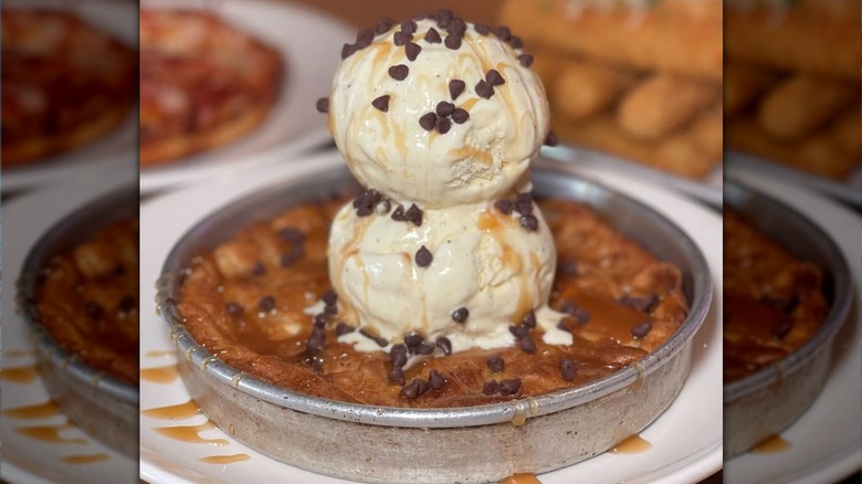 A chocolate chip Pizookie in a tin, topped with two scoops of ice cream.