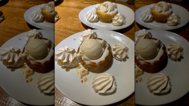 A round butter cake on a plate with cream and ice cream