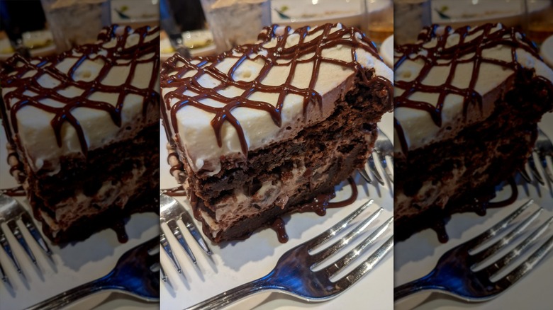 A slice of a chocolate brownie and mousse dessert