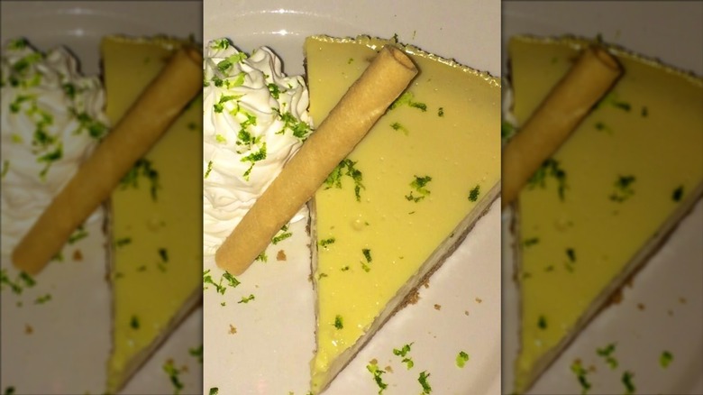 A slice of key lime pie with cream on a plate