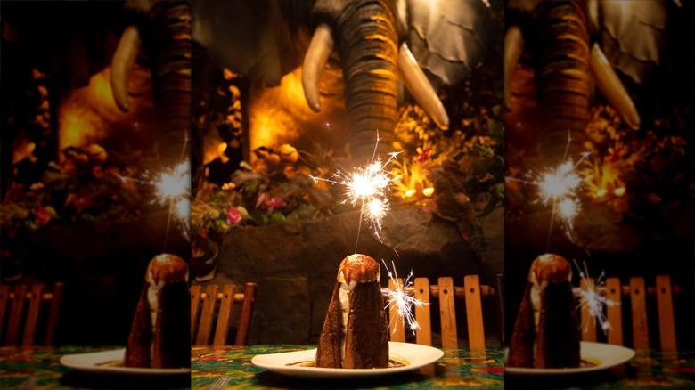 A sparkling volcano cake from the Rainforest Cafe in front of an elephant animatronic