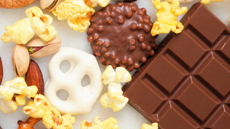 Close up of a chocolate bar, popcorn, almonds, and pistachios