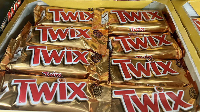 A box of Twix chocolate candy bars on a store shelf.