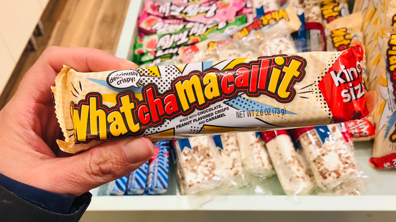 A hand holding a Whatchamacallit candy bar