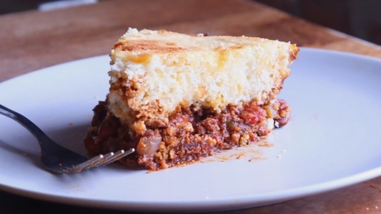 A slice of chili-cornbread skillet pie on a plate with a fork