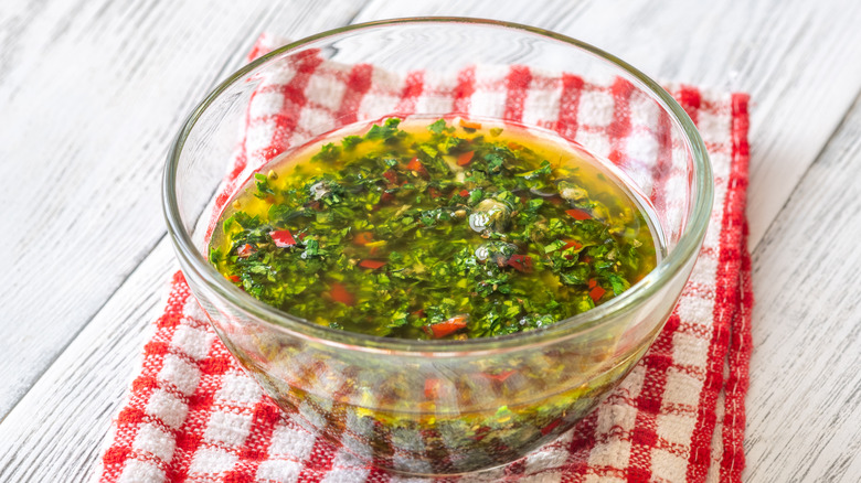 glass ramekin of chimichurri on red and white napkin