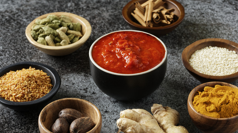 harissa ramekin surrounded by herbs and spices