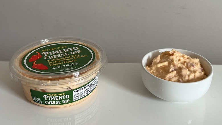 A tub of Trader Joe's pimento cheese dip with a little bowl of it