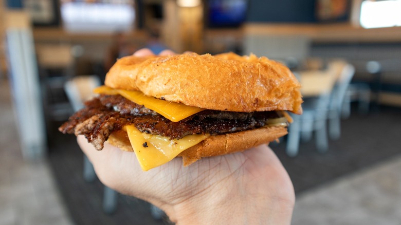 Person holding Culver's burger in restaurant in palm