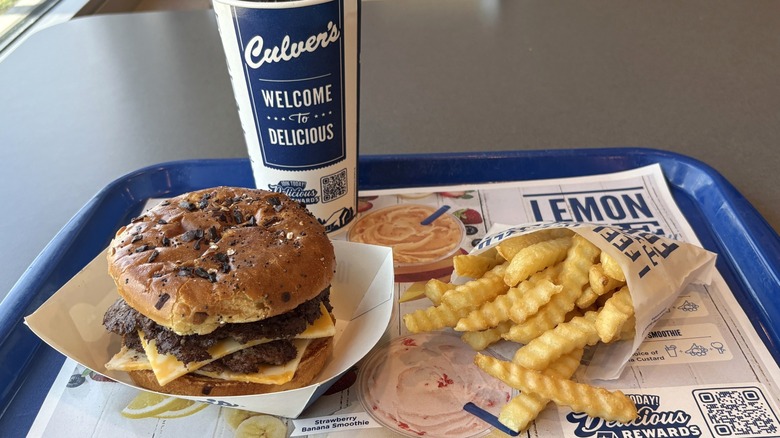 Culver's burger, fries, and drink on tray in restaurant