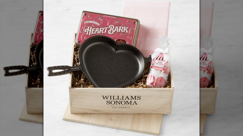 Williams Sonoma I Heart You Gift Crate filled with heart-shaped pan, heart-shaped lollipops, dish towel, and strawberry bark