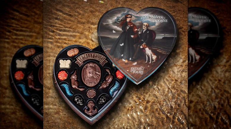 An opened box of chocolates from Fatally Yours Lighthouse Collection on top of water