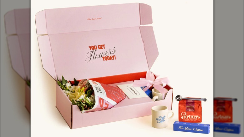 The Valentine's Day Coffee Send box with bouquet of flowers, cup, coffee, and coffee scoop