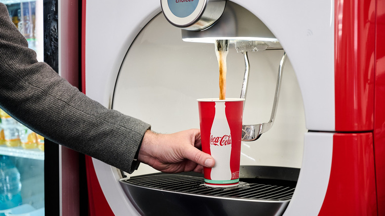 Pouring coke out of a machine