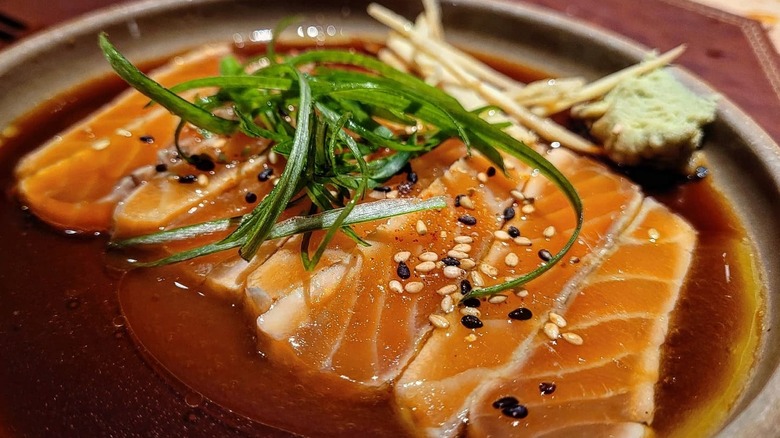 Sliced salmon and sesame seeds in a sauce