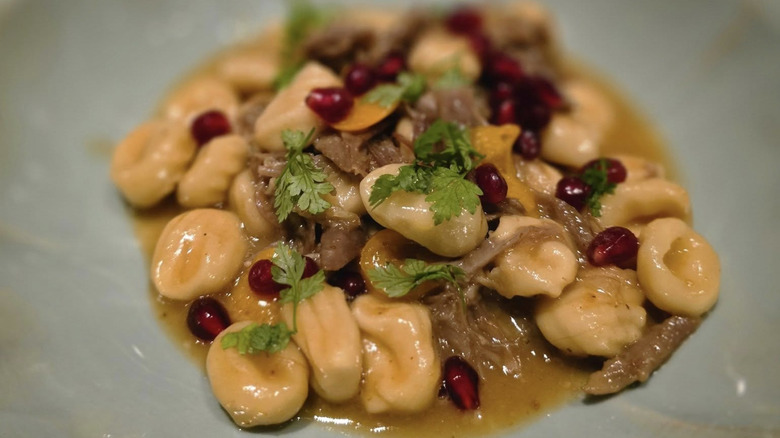 A plate of pasta with pomegranate seeds