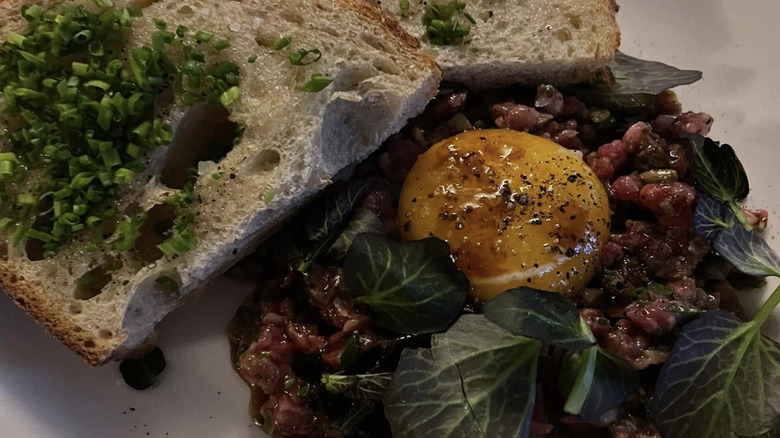 Egg yolk appetizer with bread and chives