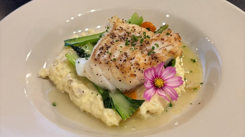 A white dish of fish and vegetables