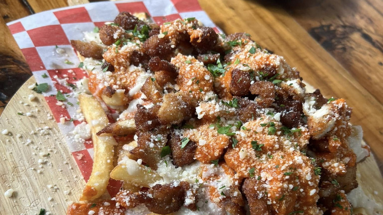Loaded fries on a wooden board