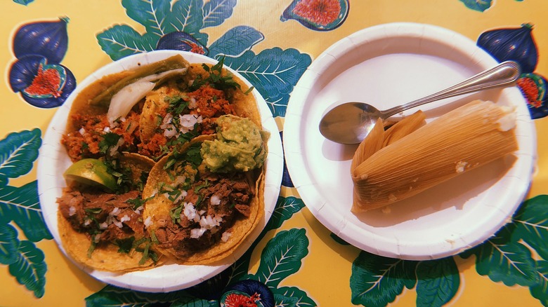 Plate of tacos and tamale on colorful table