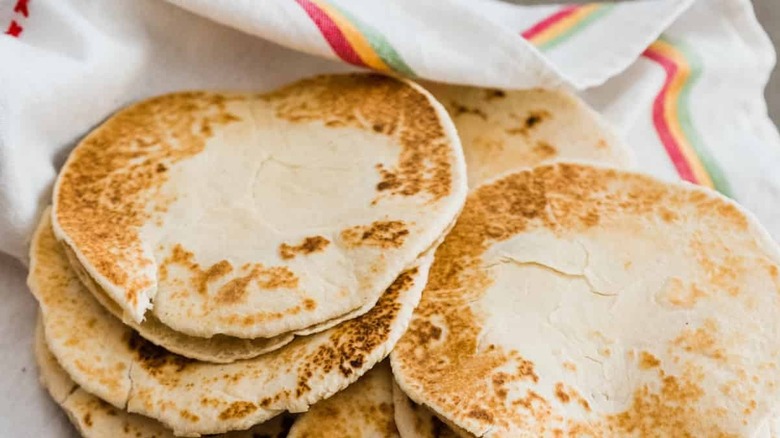 A kitchen towel filled with rounds of corn gorditas