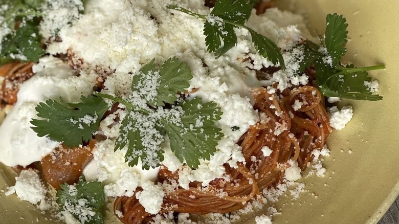 Roasted vermicelli topped with cheese and cream and parsley leaves