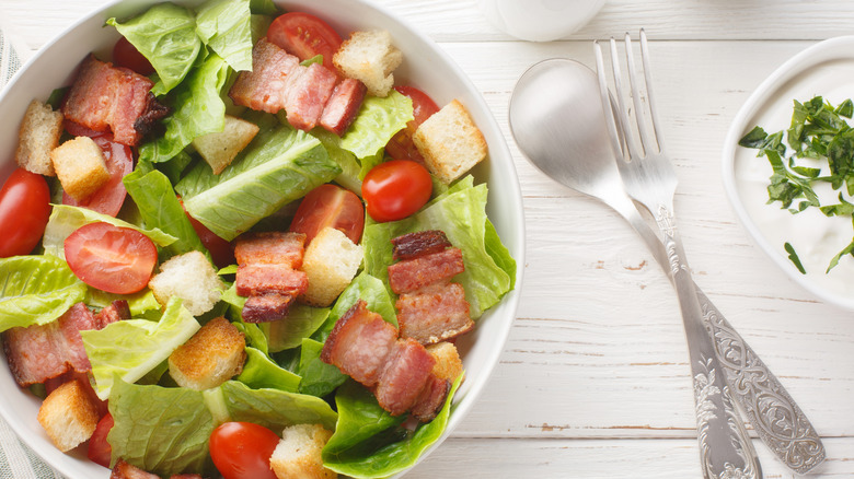Salad with bacon, lettuce, and tomato, with silverware