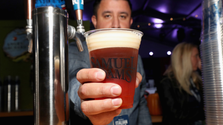A bartender serving a pint of Samuel Adams Boston Lager