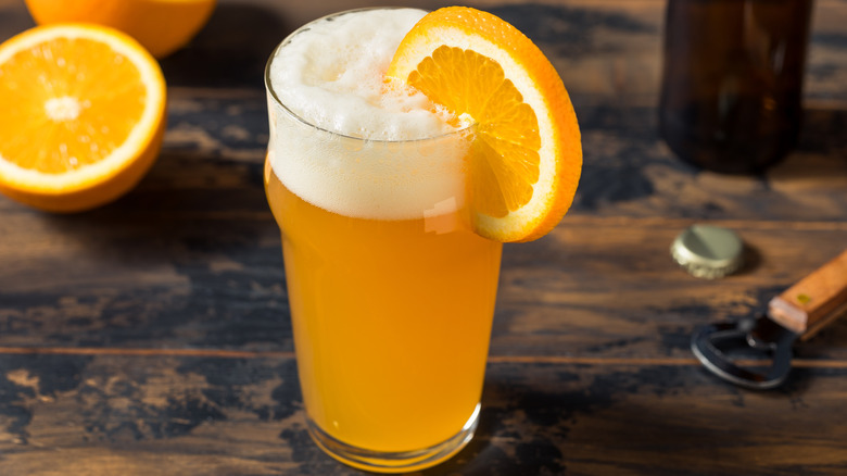 A glass of witbier with an orange slice