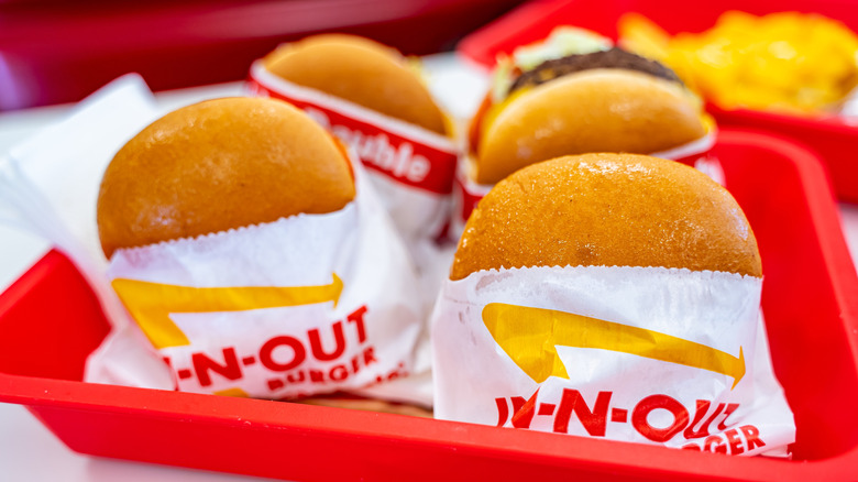 Four In-N-Out burgers on red tray.