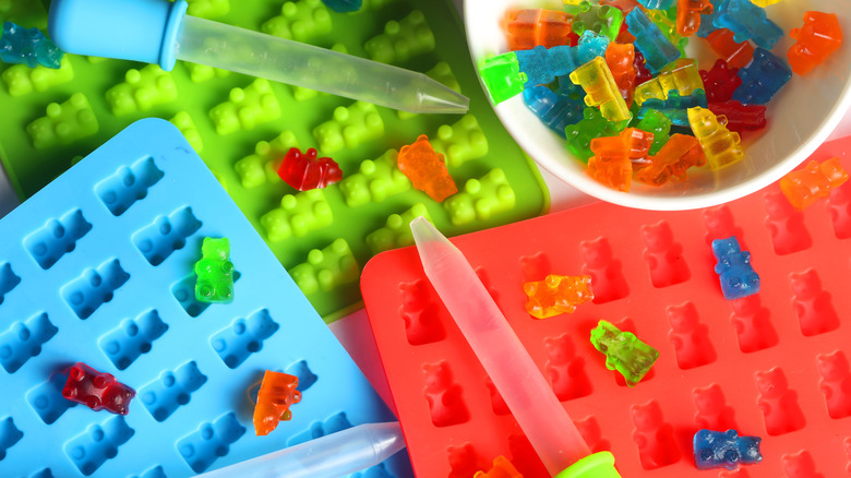 Gummy bears sitting on top of silicone molds.