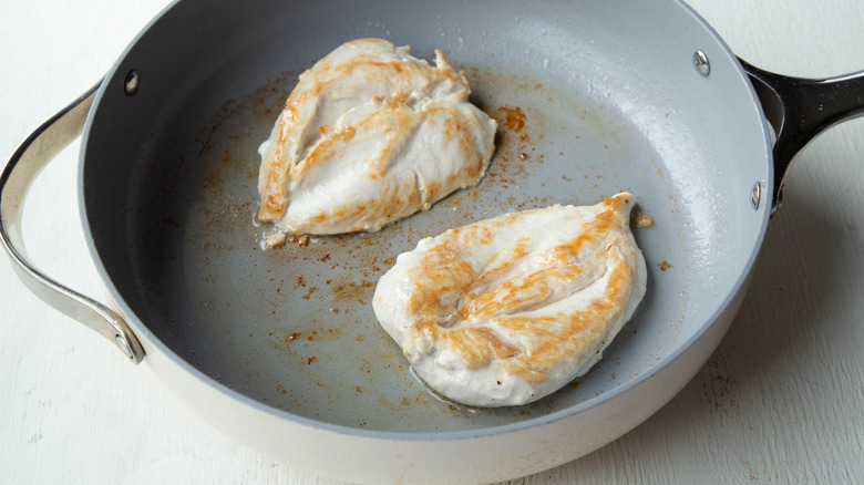 cooked chicken breasts in a frying pan