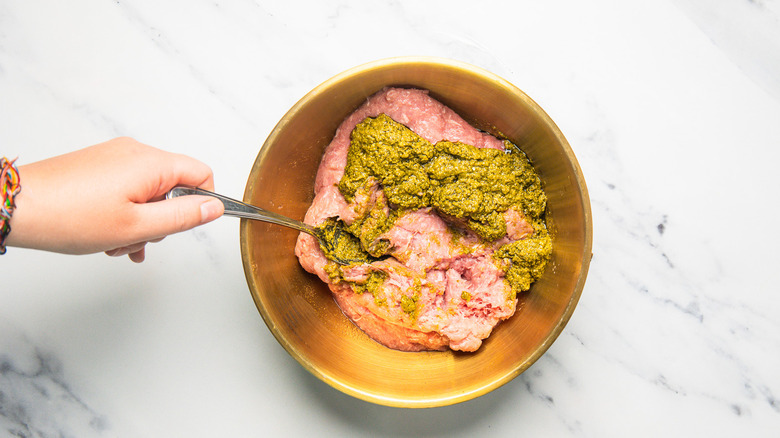 Mixing turkey burger mix in bowl.