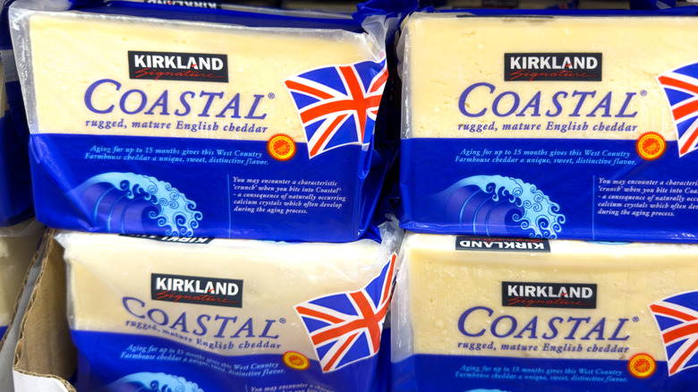 Blue and yellow packages of Coastal Cheddar in a box on a Costco shelf