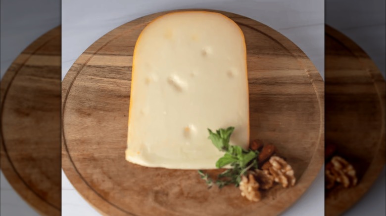 A piece of the Marieke Premium Gouda sold at Costco on a wooden board.
