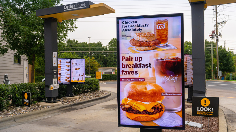 The McDonald's drive-thru advertising breakfast sandwiches early in the morning.
