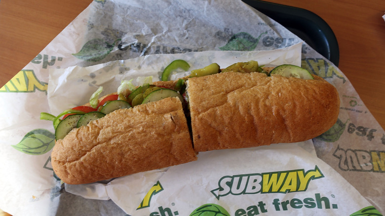 A Subway sandwich unwrapped on its packaging