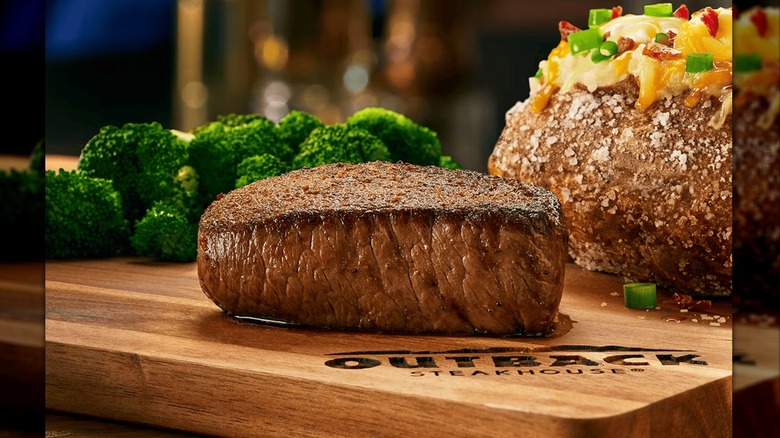 The Center Cut Sirloin from Outback Steakhouse beside broccoli and a loaded baked potato