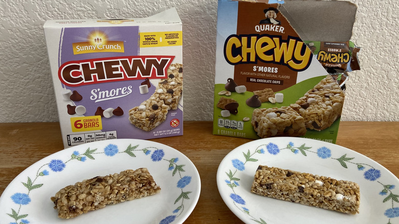 A Sunny Crunch bar and a Quaker bar on plates in front of their boxes