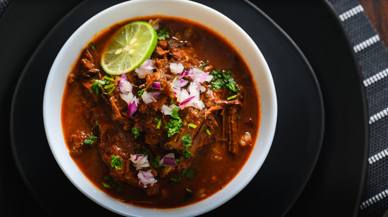 A dish of carne guisada served on a black plate.