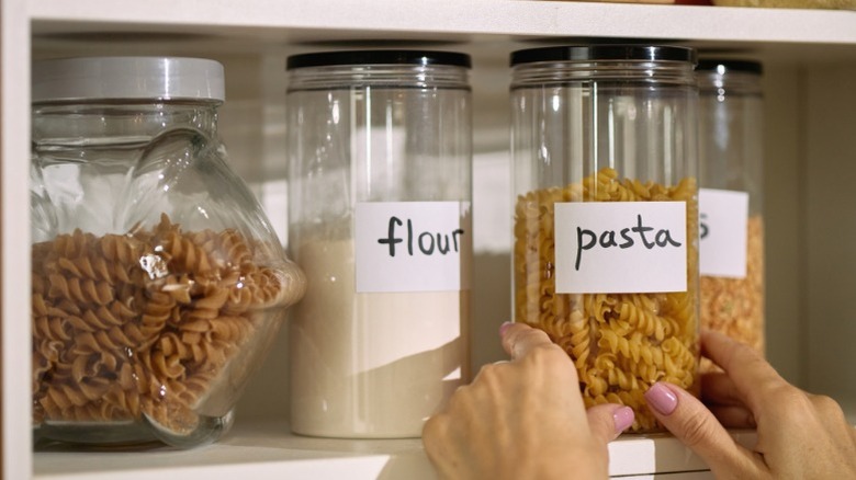 Dry ingredients like flour and pasta being stored in jars.