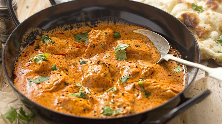 Butter chicken curry cooking in a pan.