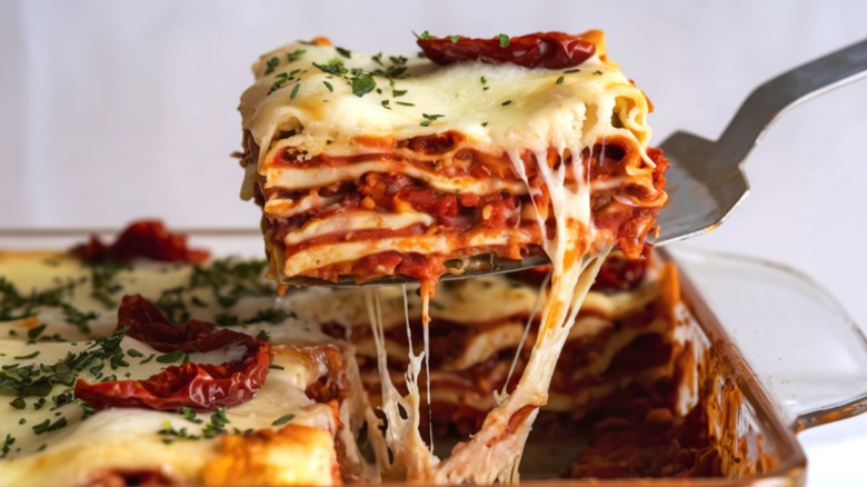 Lasagna being pulled from a pan with a satisfying cheese pull.