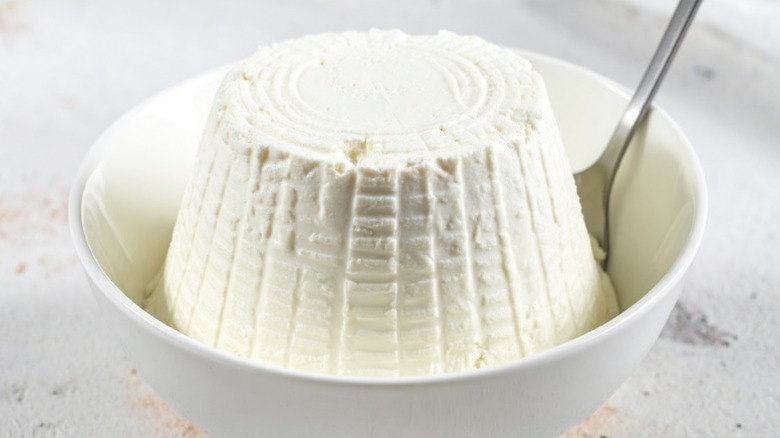 Fresh ricotta cheese in a white bowl.