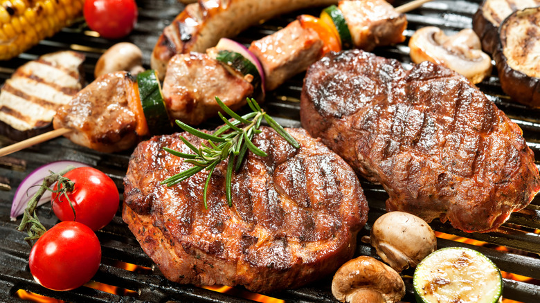 Steaks, kabobs, and assorted vegetables on the grill