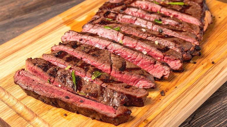 Grilled and sliced skirt steak on wood board