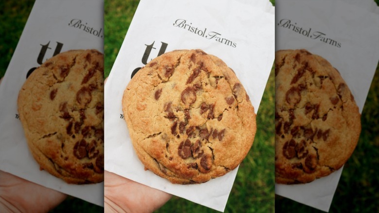 hand holding a chocolate chunk cookie on a Bristol Farms napkin