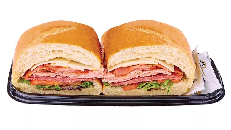 Danny's Favorite Sub cut in half on a black plastic tray with condiment packets on a white background