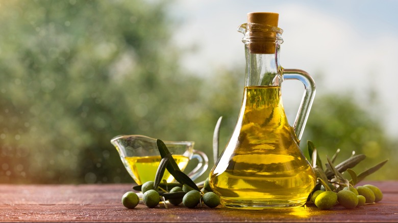 Glass bottle olive oil on wooden table